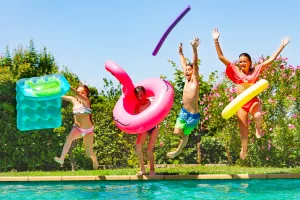 Kids and Au Pair jumping in to pool