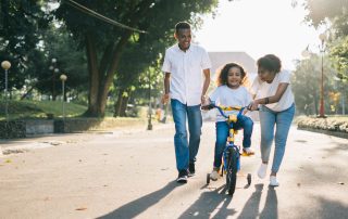 kid riding bike with parents