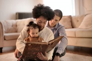 parents reading to their daughter