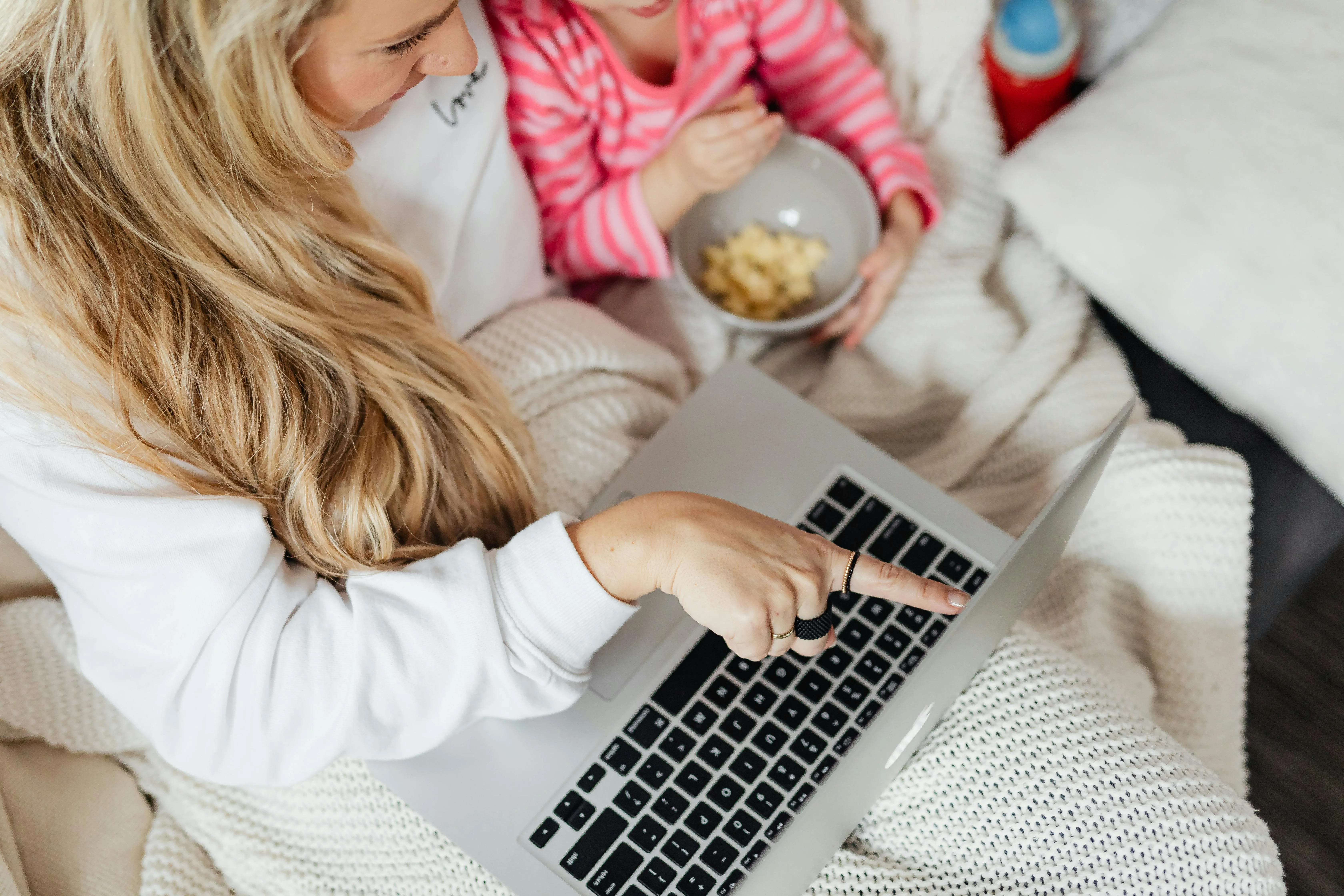 Au Pair and toddler watching show on a laptop