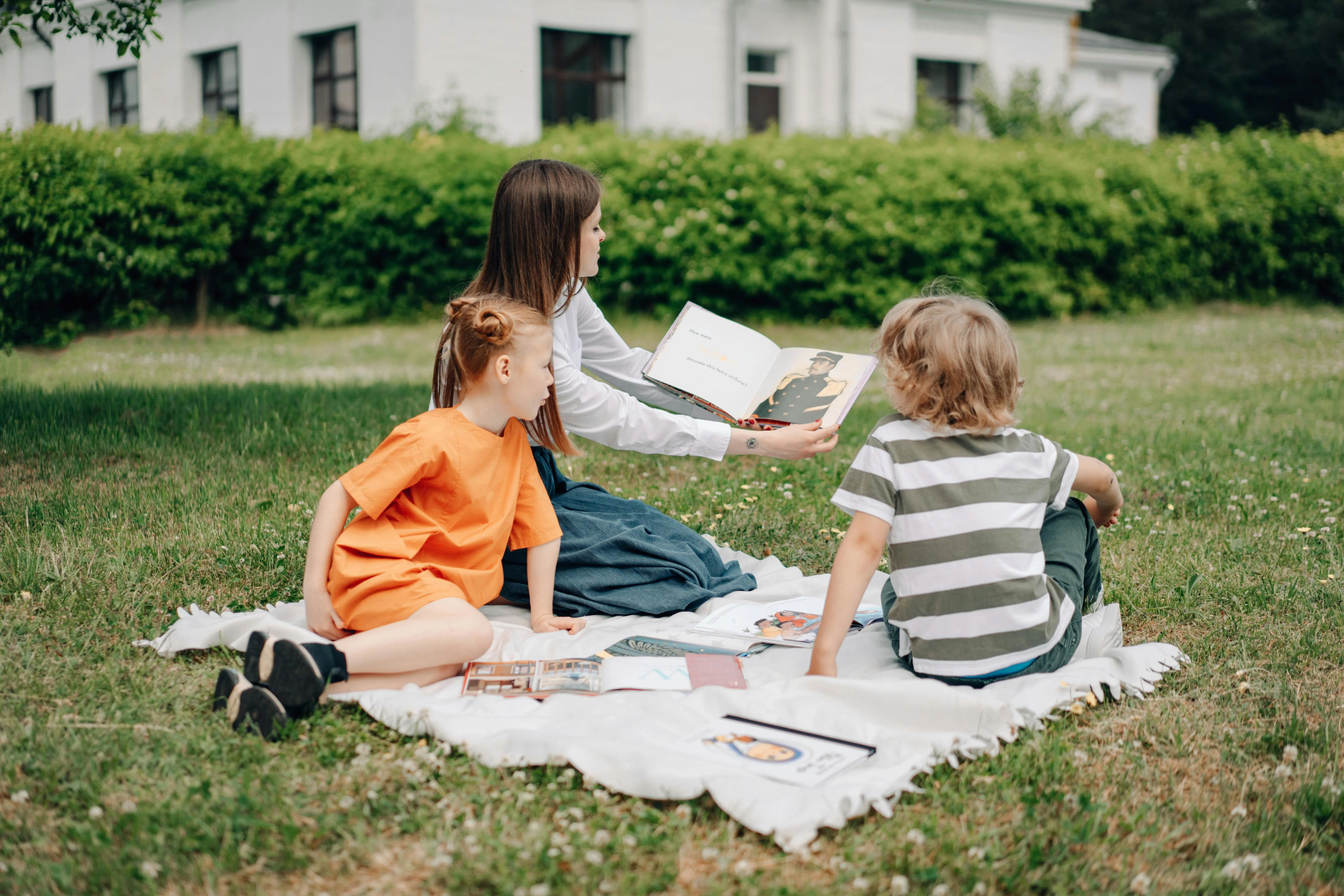 Summer Au Pair and kids reading outside