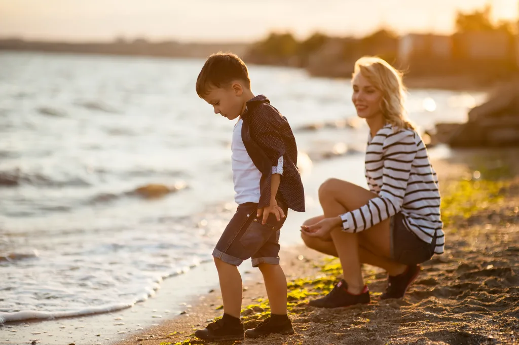 A young boy enjoys weekend childcare on the beach with their Au Pair