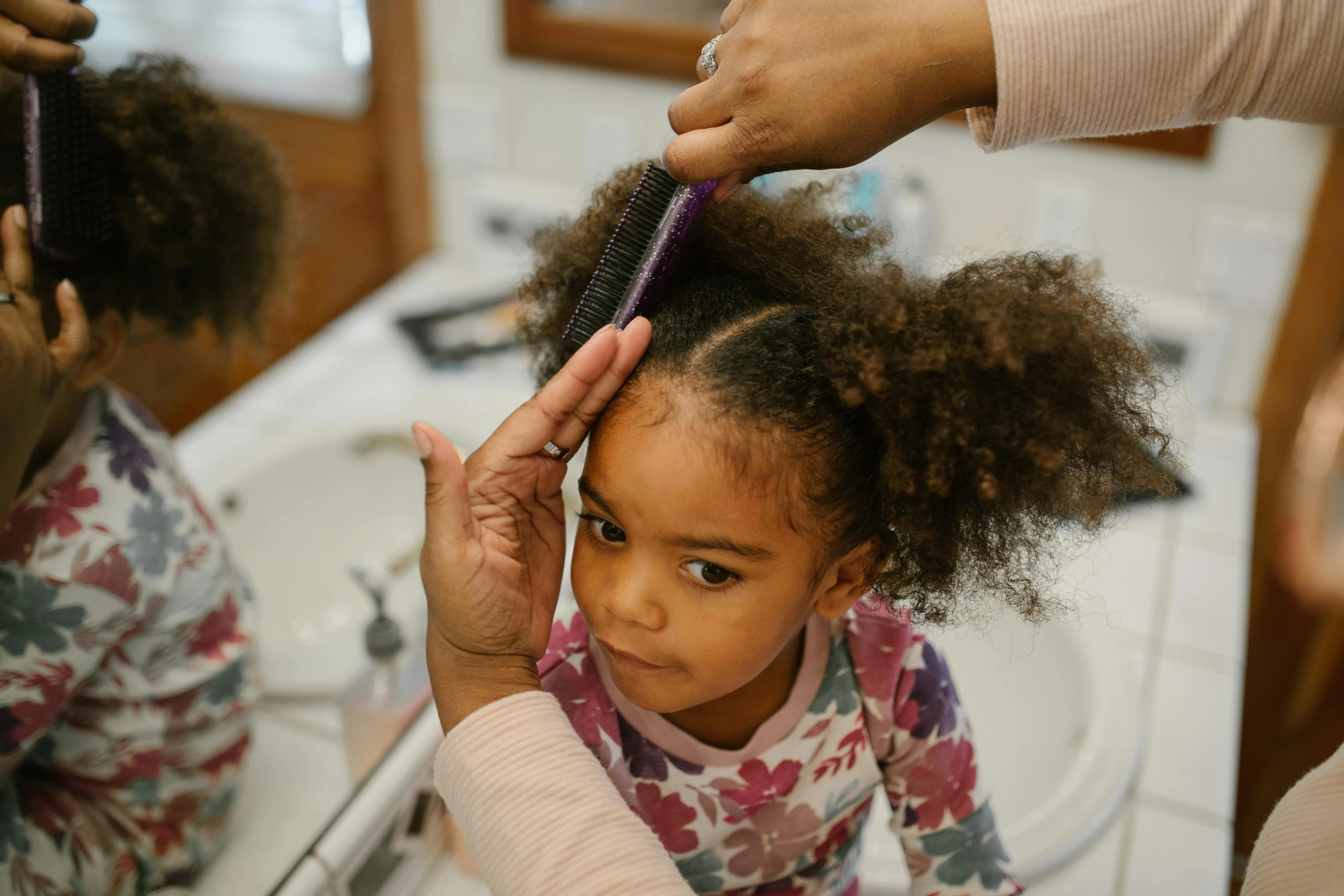 Au Pair fixing child's hair