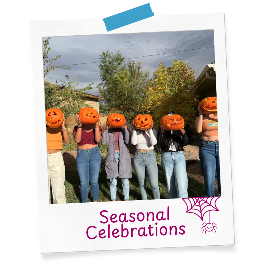 Au Pairs holding up carved pumpkins