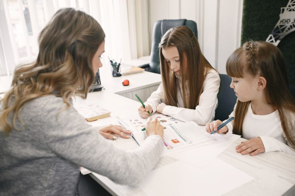 Au Pair helping two children with homework