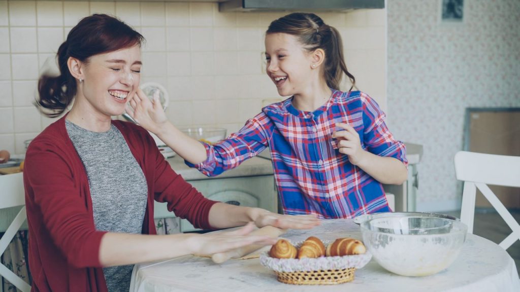 Au Pair and child baking together